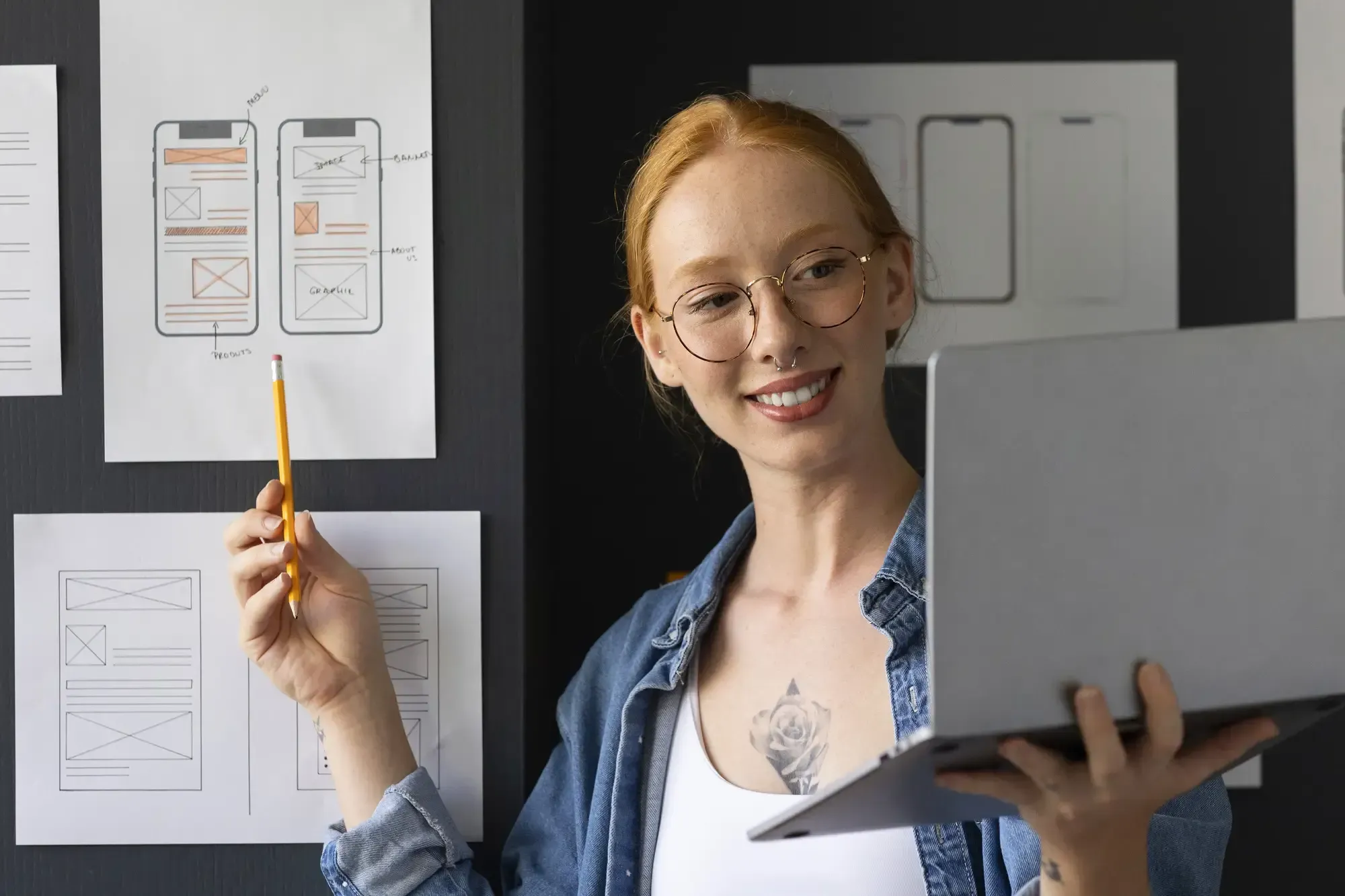 female web designer holding a laptop showcasing her design 